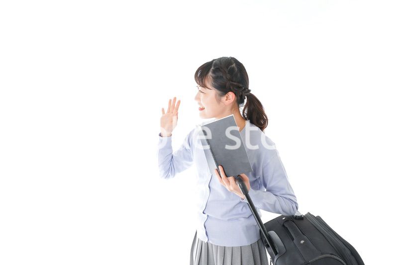 ガイドブックを持ち一人旅をする若い女性