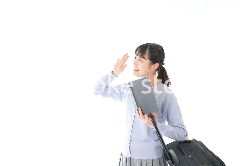 ガイドブックを持ち一人旅をする若い女性