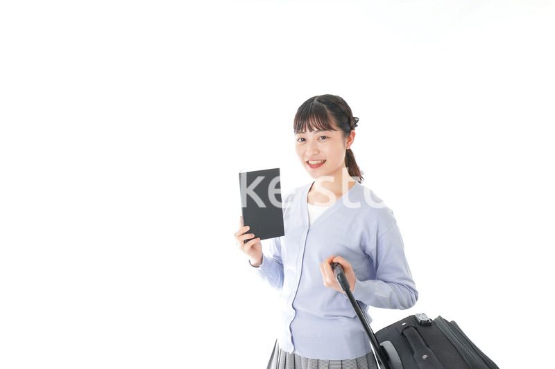 ガイドブックを持ち一人旅をする若い女性