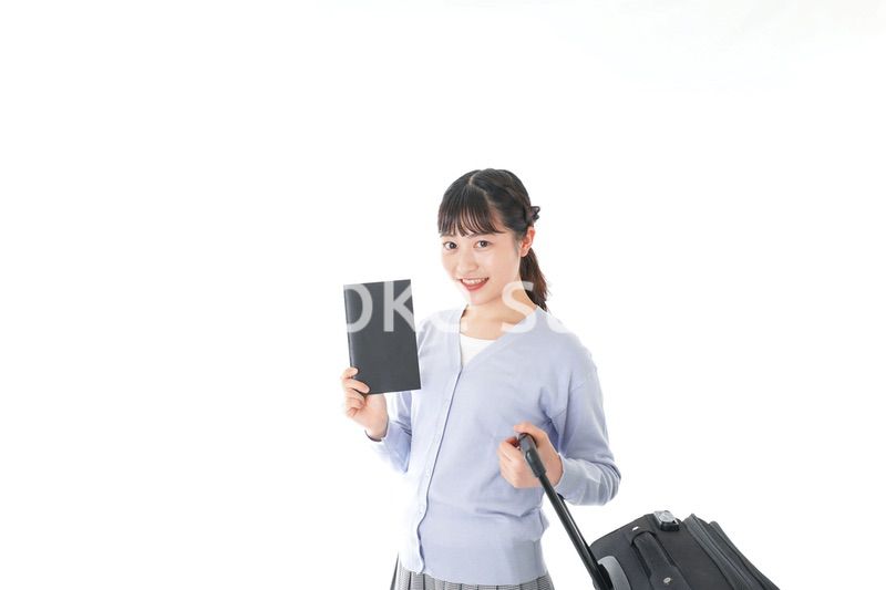 ガイドブックを持ち一人旅をする若い女性