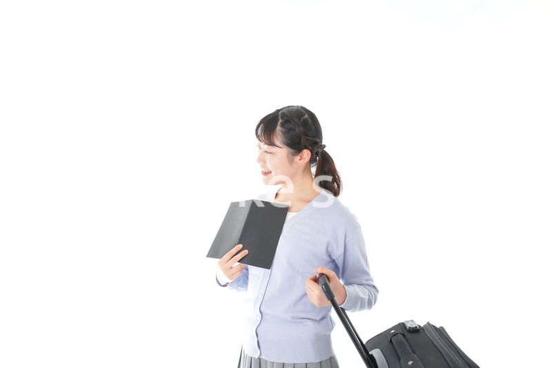 ガイドブックを持ち一人旅をする若い女性