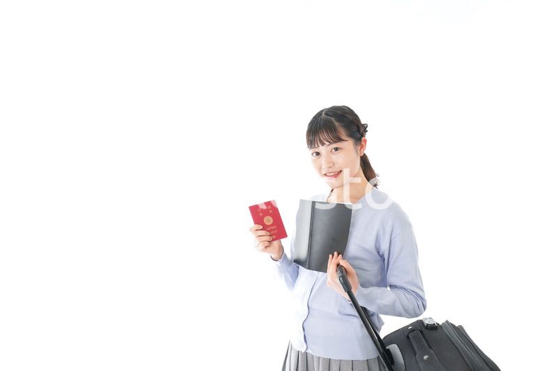 ガイドブックを持ち一人旅をする若い女性