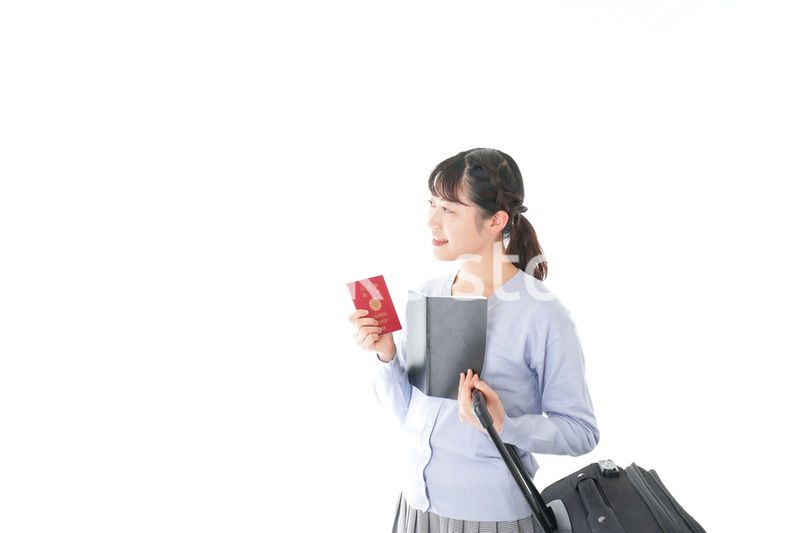 ガイドブックを持ち一人旅をする若い女性