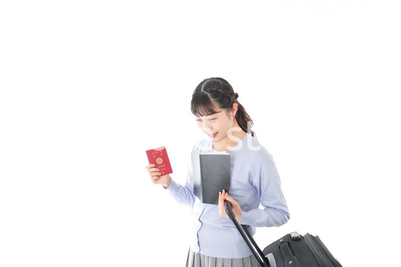 ガイドブックを持ち一人旅をする若い女性