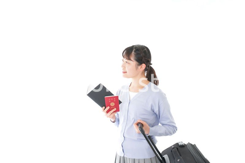 ガイドブックを持ち一人旅をする若い女性