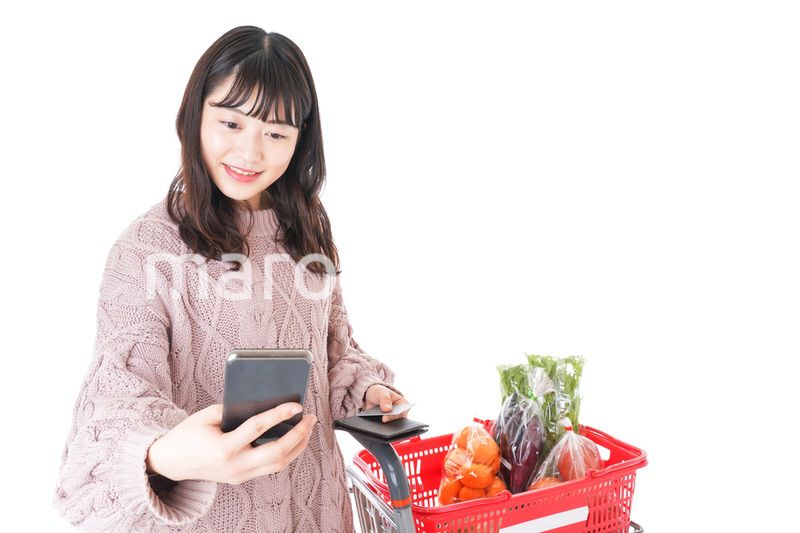 スーパーでキャッシュレス決済をする若い女性