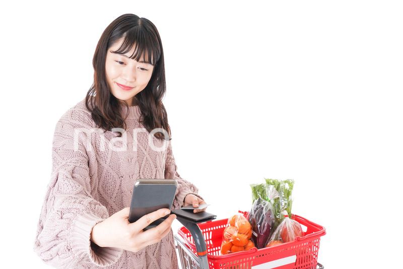スーパーでキャッシュレス決済をする若い女性