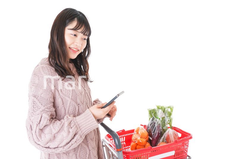 スーパーでキャッシュレス決済をする若い女性