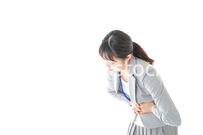 腹痛で苦しむ若いキャリアウーマン