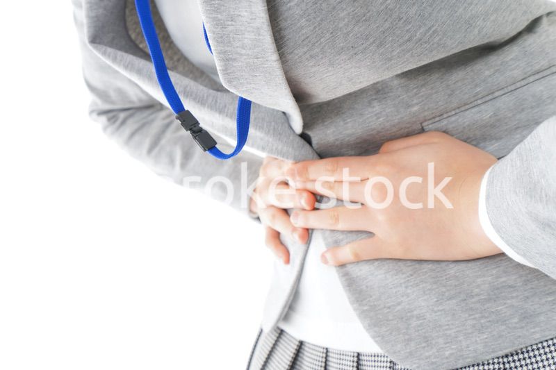 腹痛で苦しむ若いキャリアウーマン