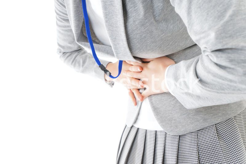 腹痛で苦しむ若いキャリアウーマン