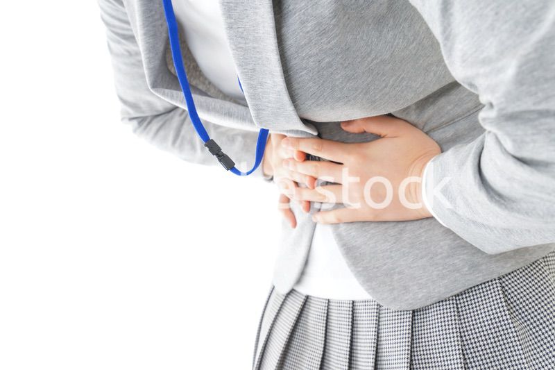 腹痛で苦しむ若いキャリアウーマン