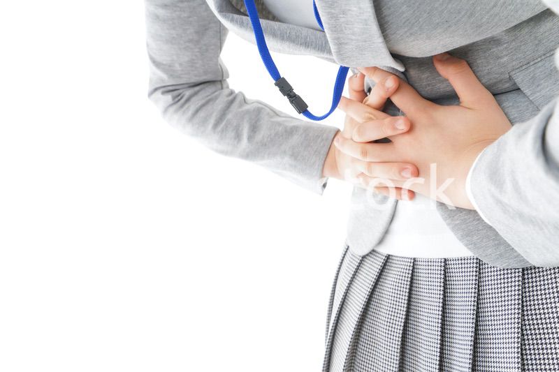 腹痛で苦しむ若いキャリアウーマン