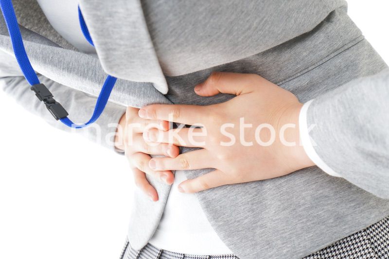 腹痛で苦しむ若いキャリアウーマン