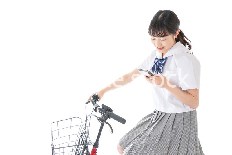 自転車でスマホを使う若い学生