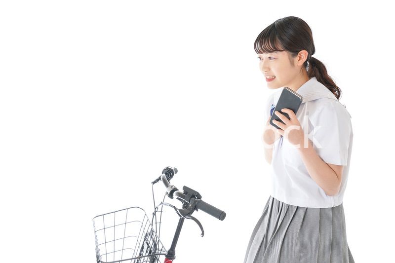 自転車でスマホを使う若い学生