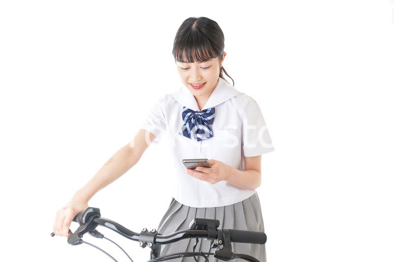 自転車でスマホを使う若い学生