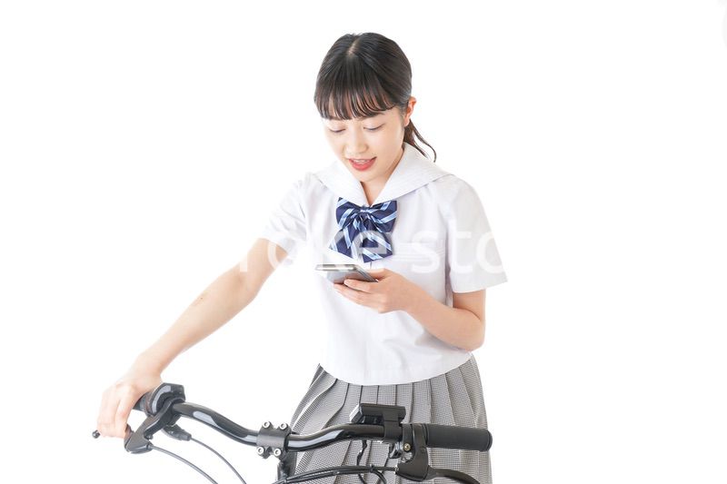 自転車でスマホを使う若い学生