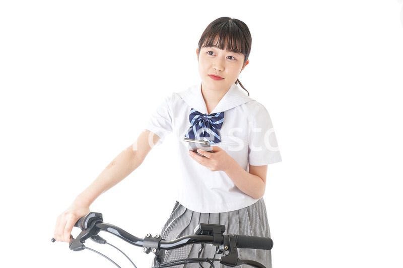 自転車でスマホを使う若い学生