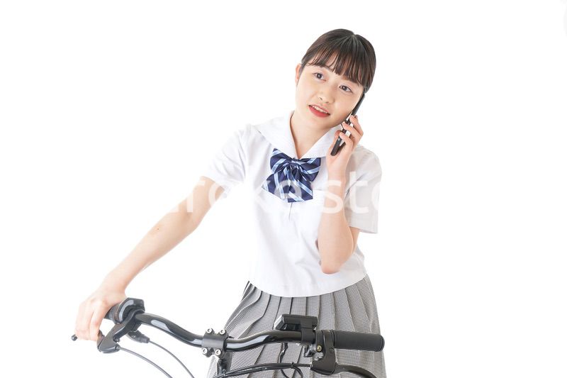 自転車でスマホを使う若い学生