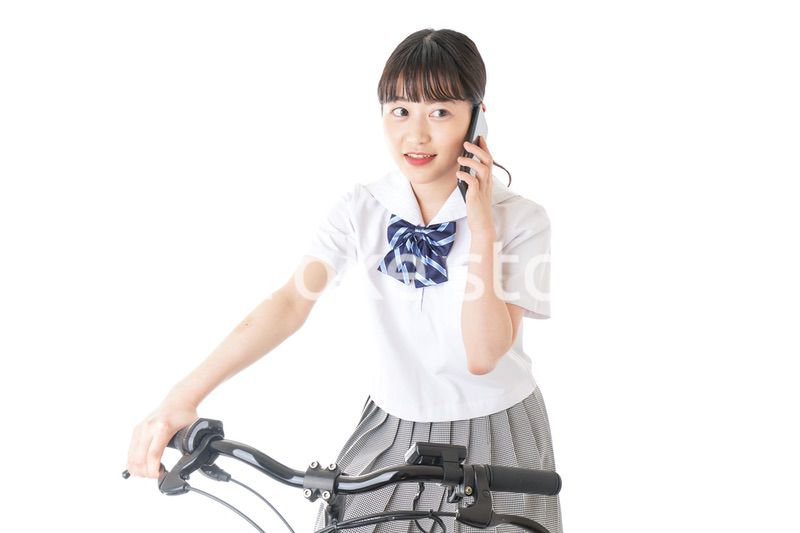 自転車でスマホを使う若い学生