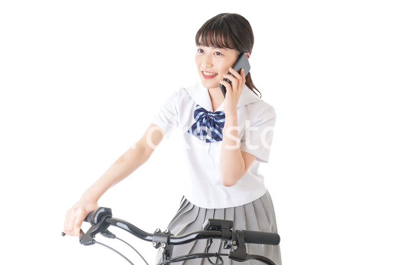 自転車でスマホを使う若い学生