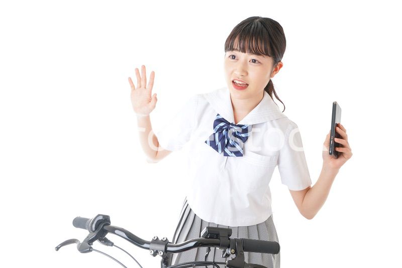 自転車でスマホを使う若い学生