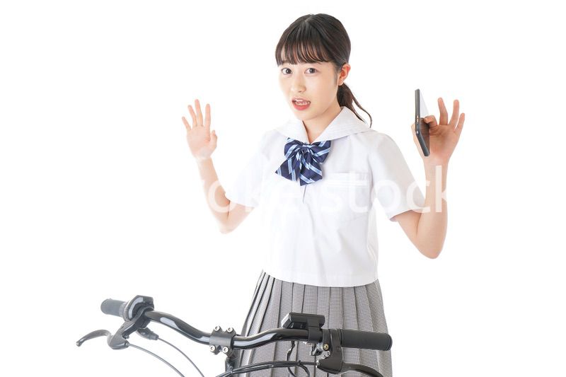 自転車でスマホを使う若い学生