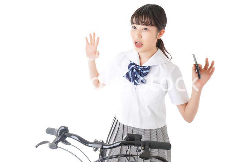 自転車でスマホを使う若い学生
