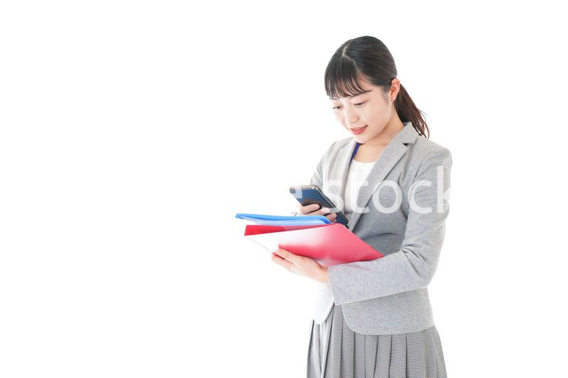 オフィスでスマートフォンを使う若いビジネスウーマン