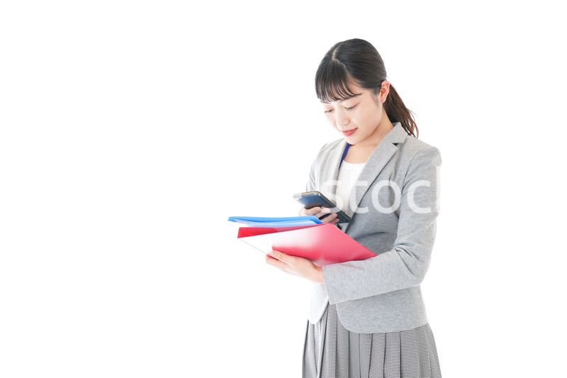 オフィスでスマートフォンを使う若いビジネスウーマン