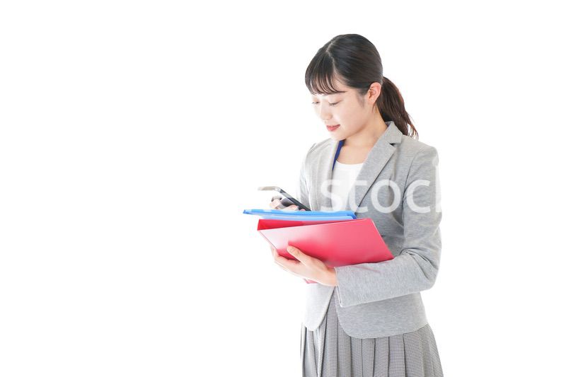 オフィスでスマートフォンを使う若いビジネスウーマン