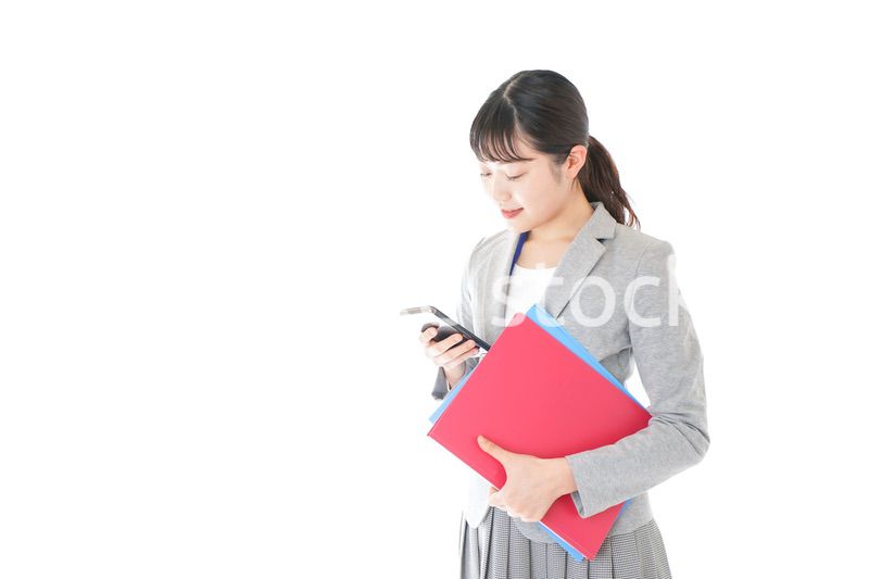 オフィスでスマートフォンを使う若いビジネスウーマン