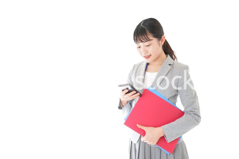 オフィスでスマートフォンを使う若いビジネスウーマン