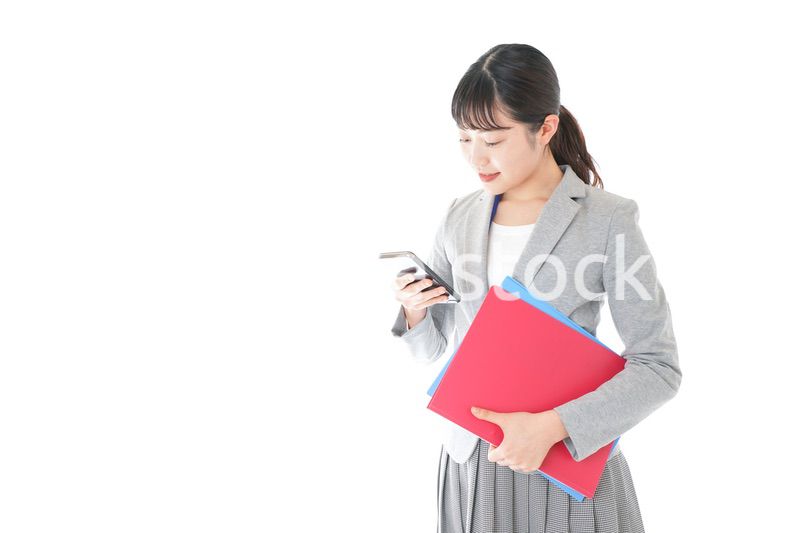 オフィスでスマートフォンを使う若いビジネスウーマン
