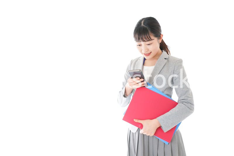 オフィスでスマートフォンを使う若いビジネスウーマン