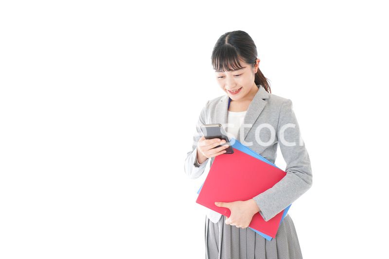 オフィスでスマートフォンを使う若いビジネスウーマン