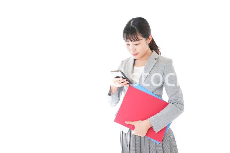 オフィスでスマートフォンを使う若いビジネスウーマン