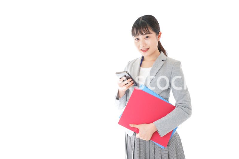 オフィスでスマートフォンを使う若いビジネスウーマン