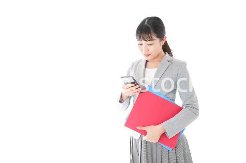 オフィスでスマートフォンを使う若いビジネスウーマン