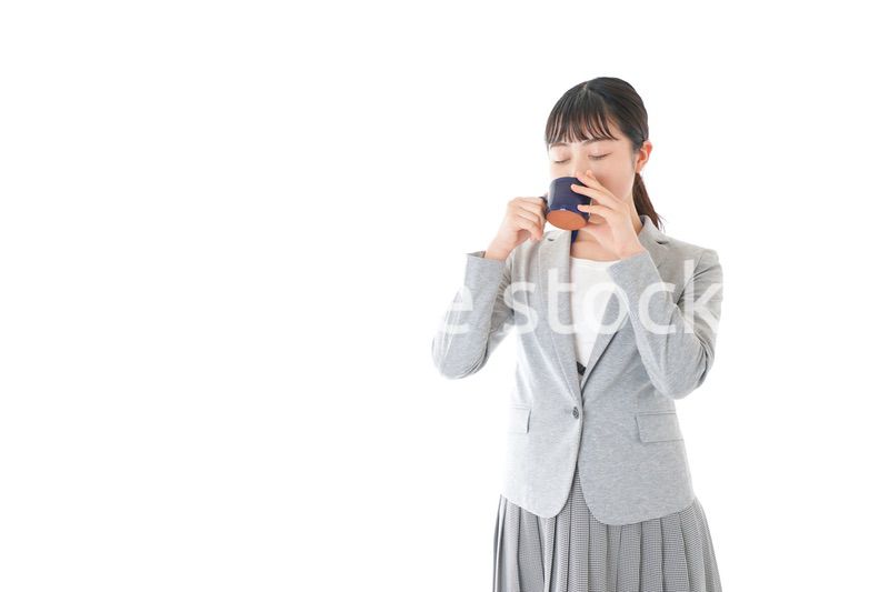 笑顔でコーヒーを飲む若いビジネスウーマン