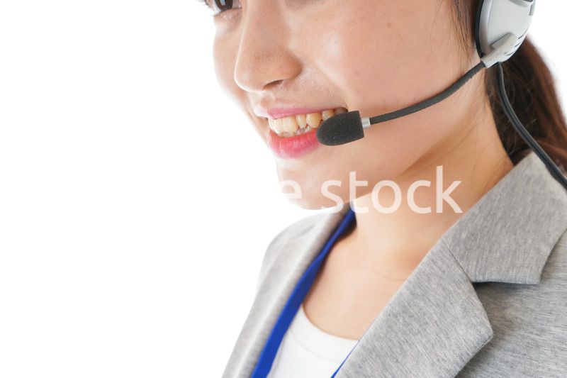 笑顔で対応をするコールセンターの女性