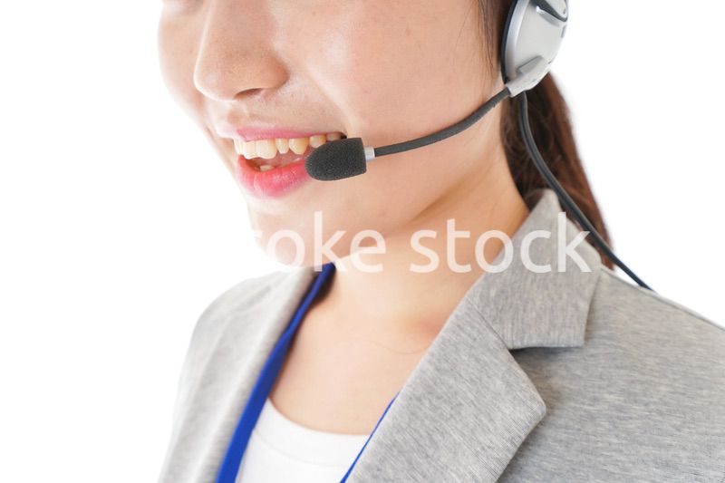 笑顔で対応をするコールセンターの女性
