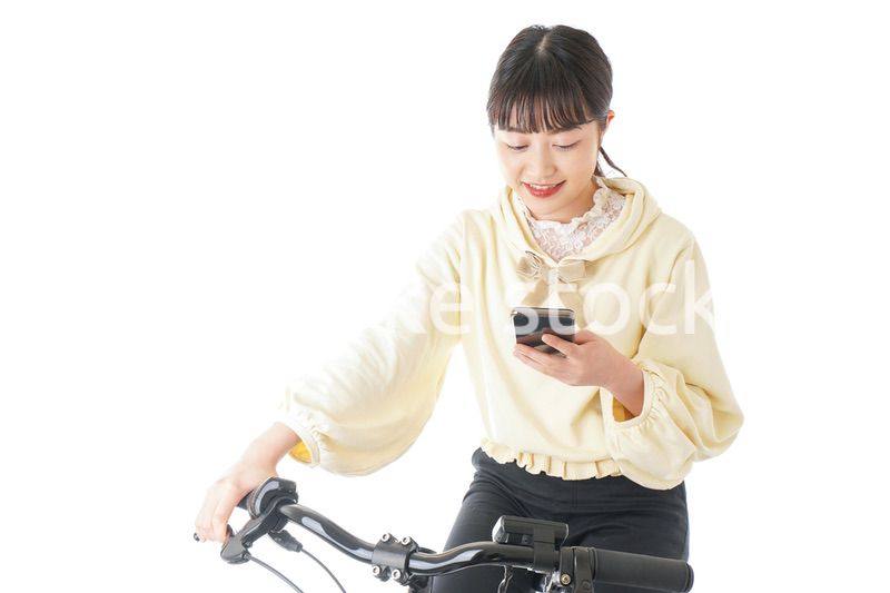 自転車でスマホを使う若い女性