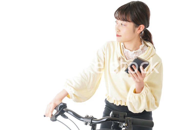 自転車でスマホを使う若い女性