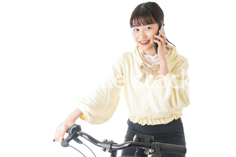 自転車でスマホを使う若い女性