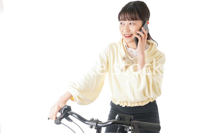 自転車でスマホを使う若い女性