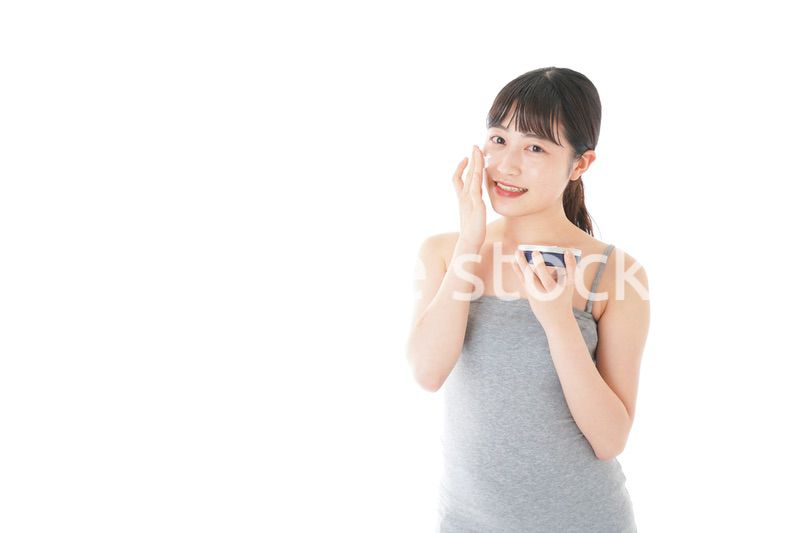 顔にクリームを塗る若い女性