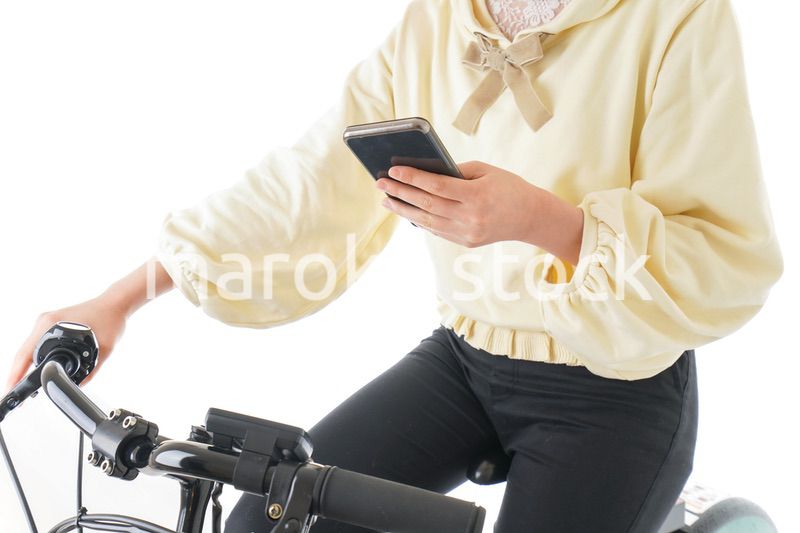自転車でスマホを使う若い女性