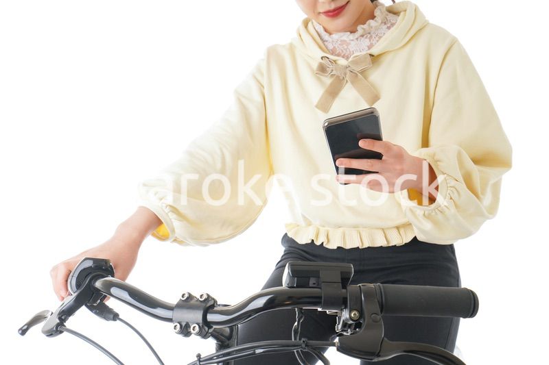 自転車でスマホを使う若い女性